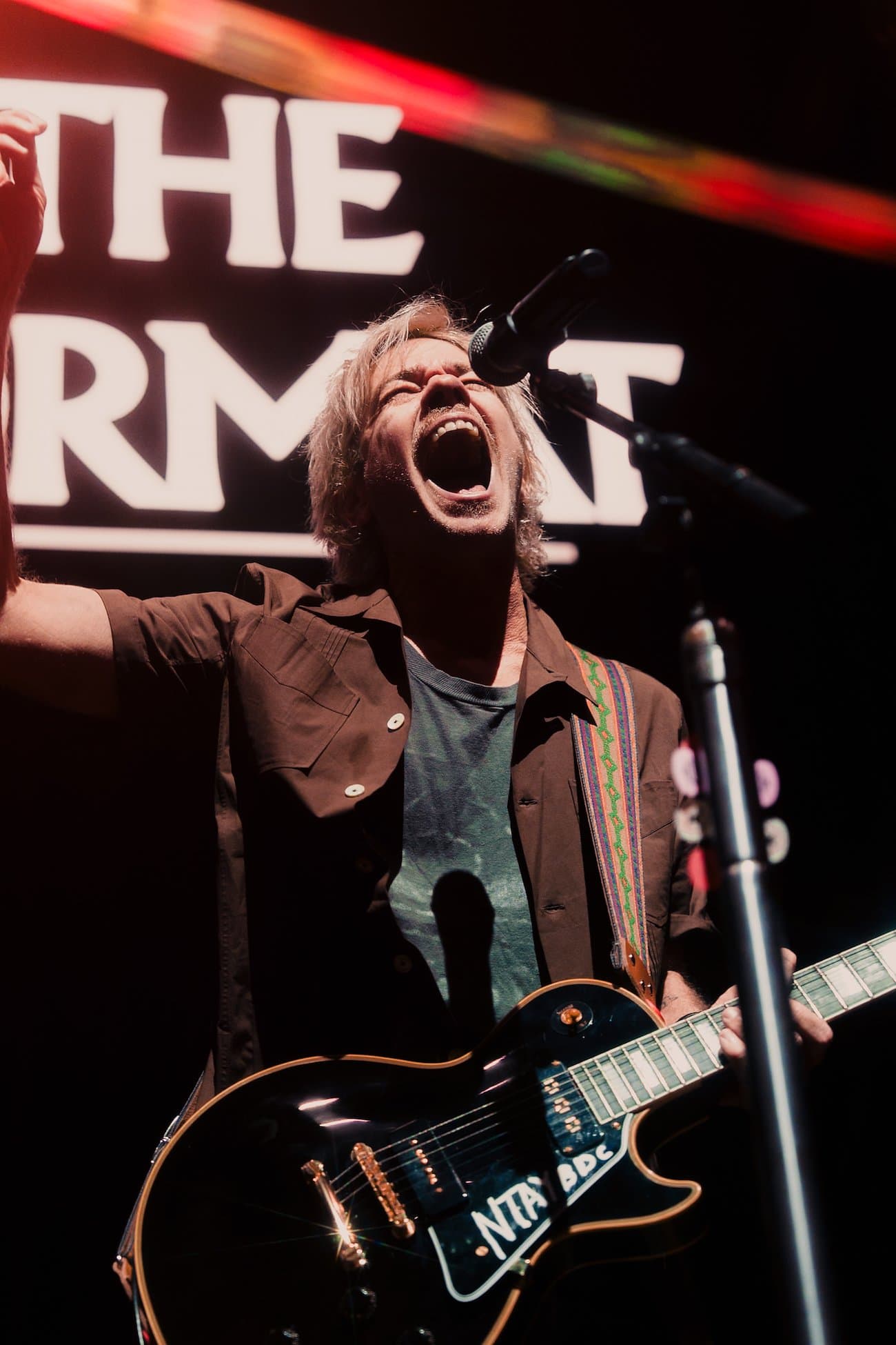 Guitarist singing into a microphone on stage