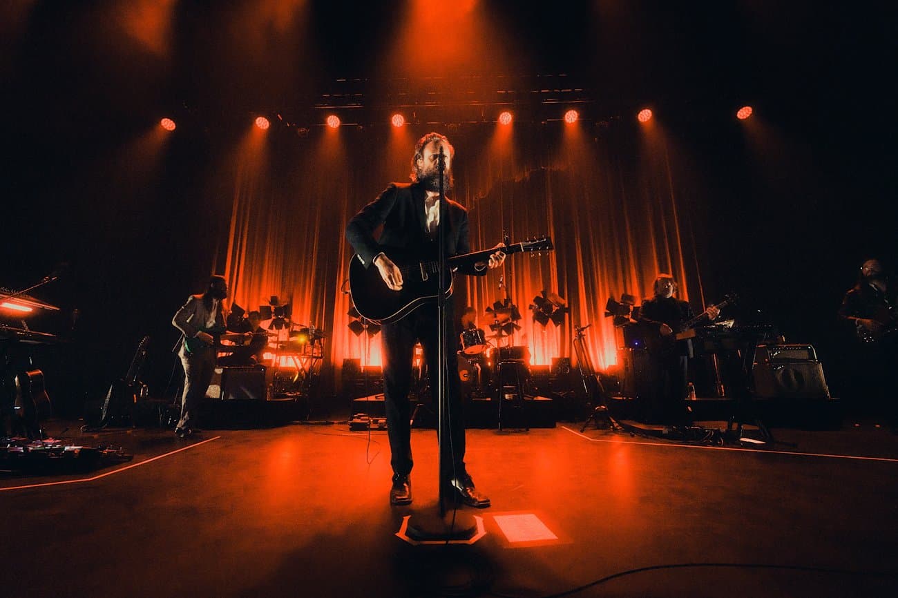 Band performing on a stage lit orange