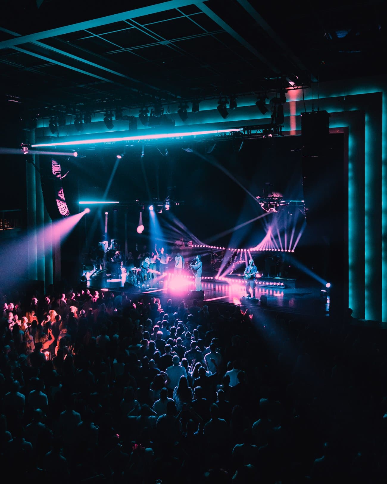 Crowd watching a concert under blue and pink light